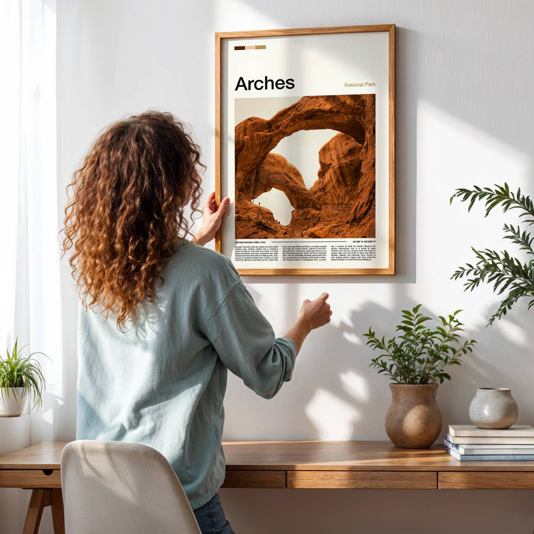 Arches Twin Rock Arches Travel Print framed on a pale wall beside houseplants