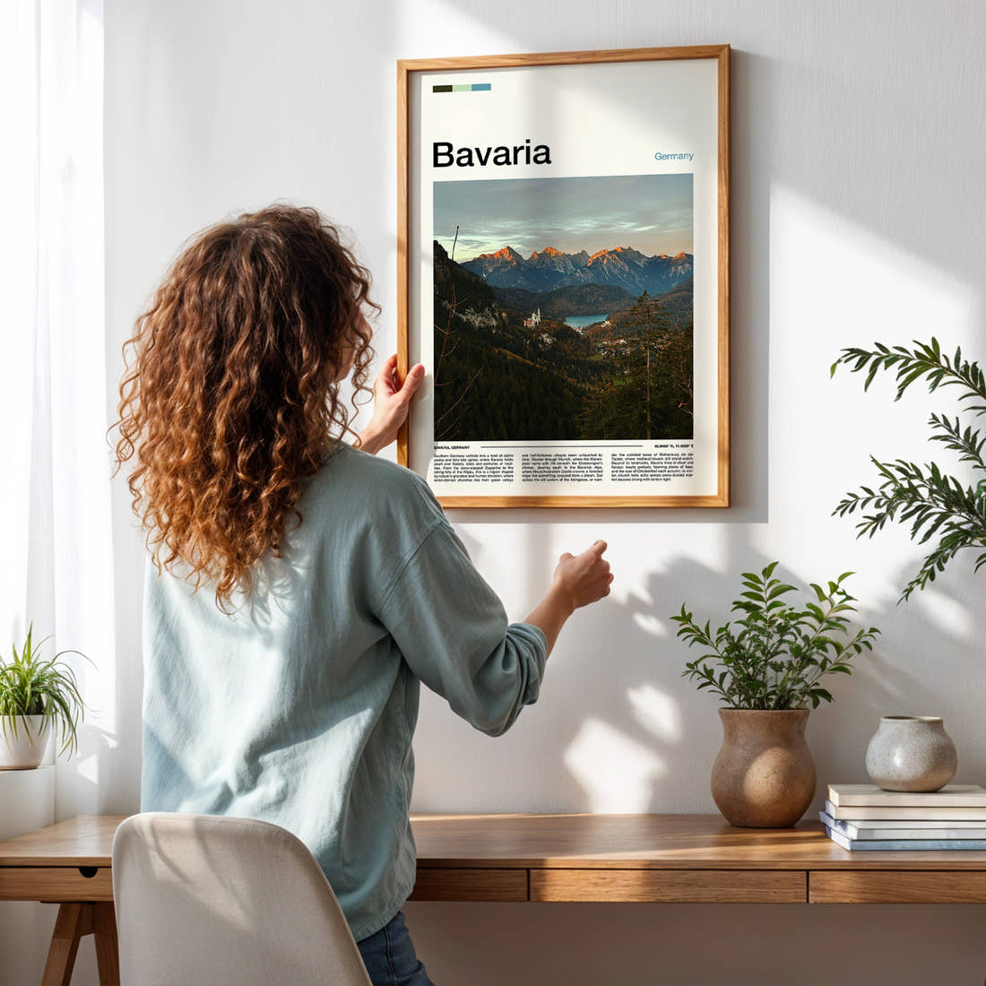 Bavaria Alpine Valley Vista Travel Print framed on a pale wall beside houseplants