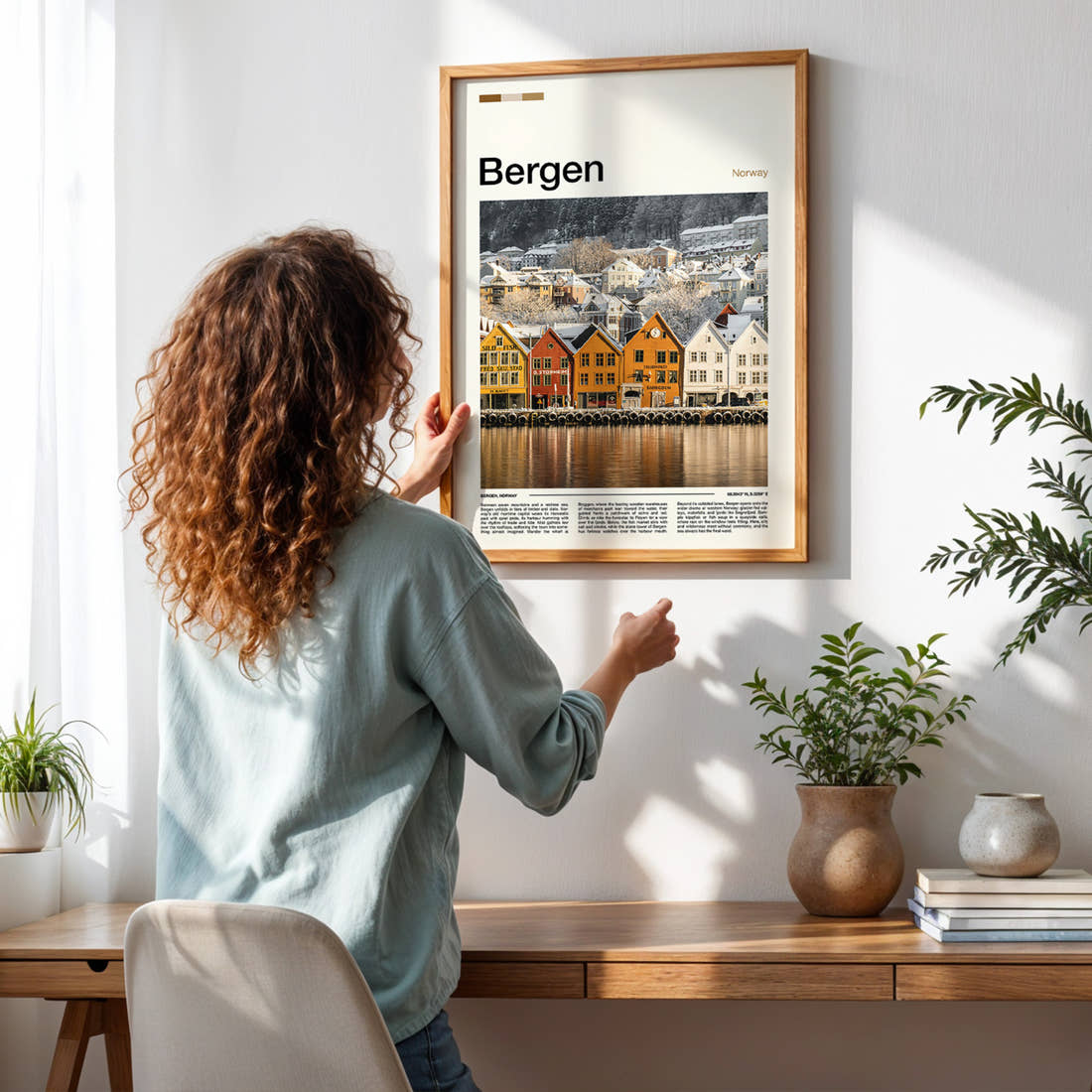Bergen Snowy Bryggen Wharf Travel Print framed on a pale wall beside houseplants