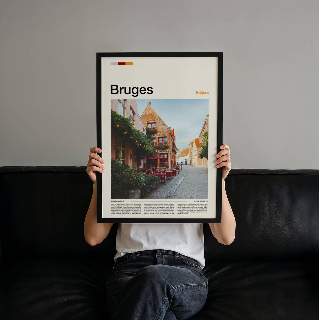 Bruges Cafe With Red Chairs Travel Print held up by hand to show the size of the print