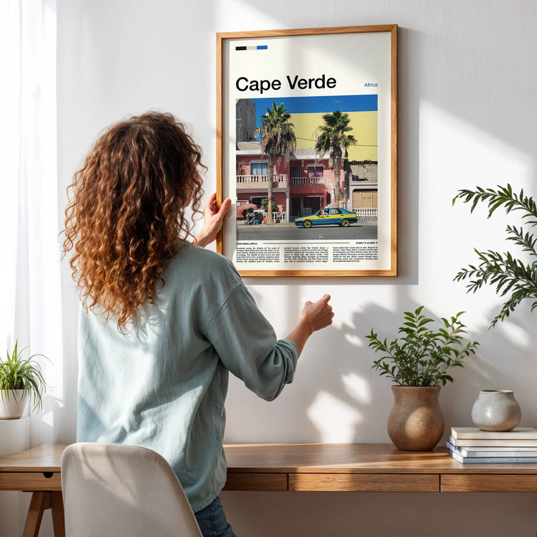 Cape Verde Colourful Harbour Taxi Travel Print framed on a pale wall beside houseplants
