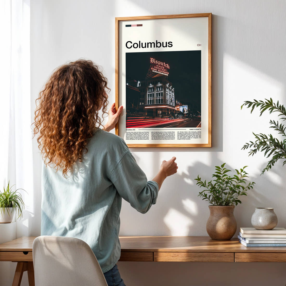 Columbus Illuminated Dispatch Building Travel Print framed on a pale wall beside houseplants