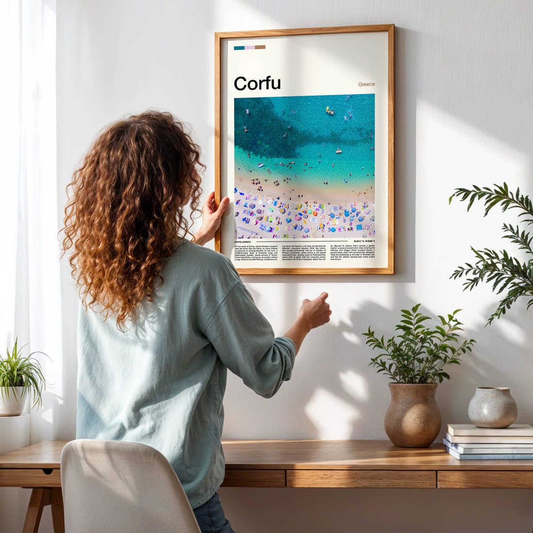 Corfu Aerial Beach View Travel Print framed on a pale wall beside houseplants