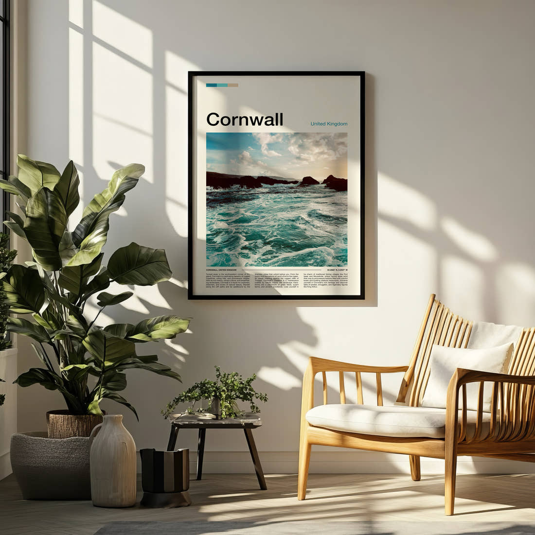Cornwall Waves On The Rocks Travel Print framed on a pale wall beside houseplants