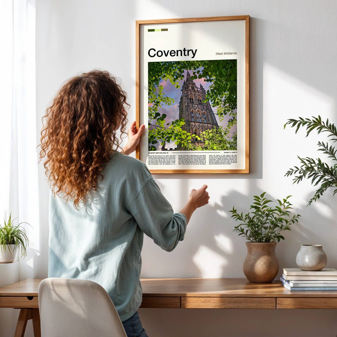 Coventry Cathedral Spire Through Leaves Travel Print framed on a pale wall beside houseplants