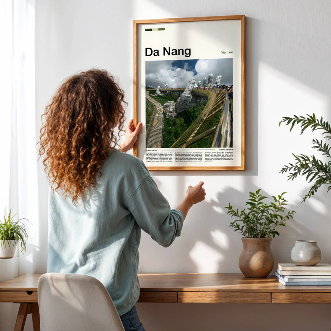Da Nang Golden Bridge Hands Travel Print framed on a pale wall beside houseplants