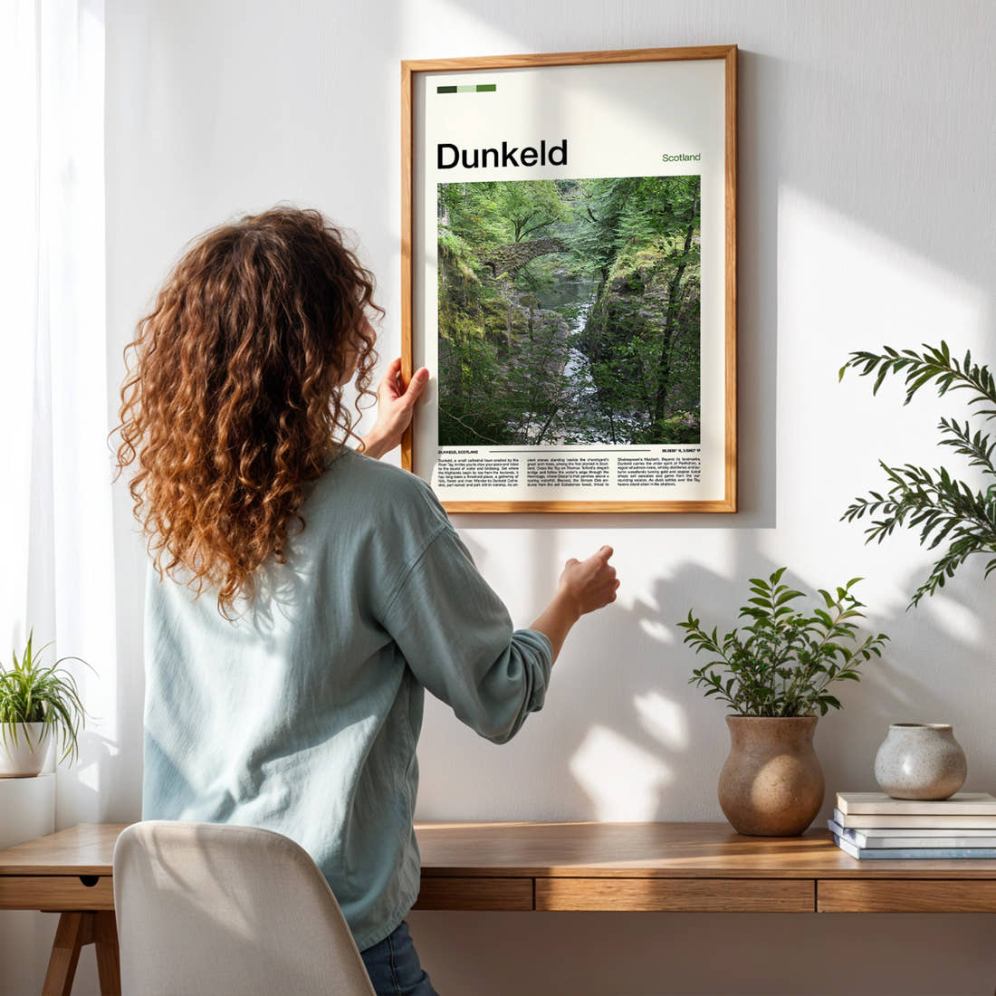 Dunkeld Mossy Gorge Bridge Travel Print framed on a pale wall beside houseplants