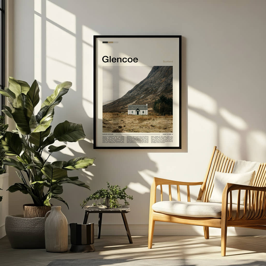 Glencoe Lone White Cottage Travel Print framed on a pale wall beside houseplants