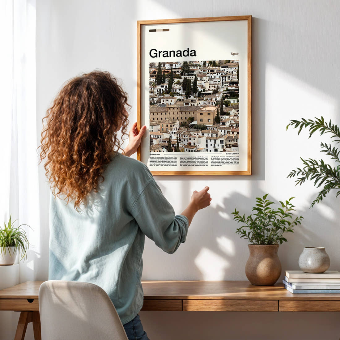 Granada Whitewashed Albaicín Houses Travel Print framed on a pale wall beside houseplants