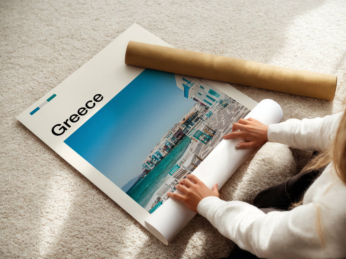 Greece Seaside Cafe Chairs Travel Print being unrolled from its postal tube