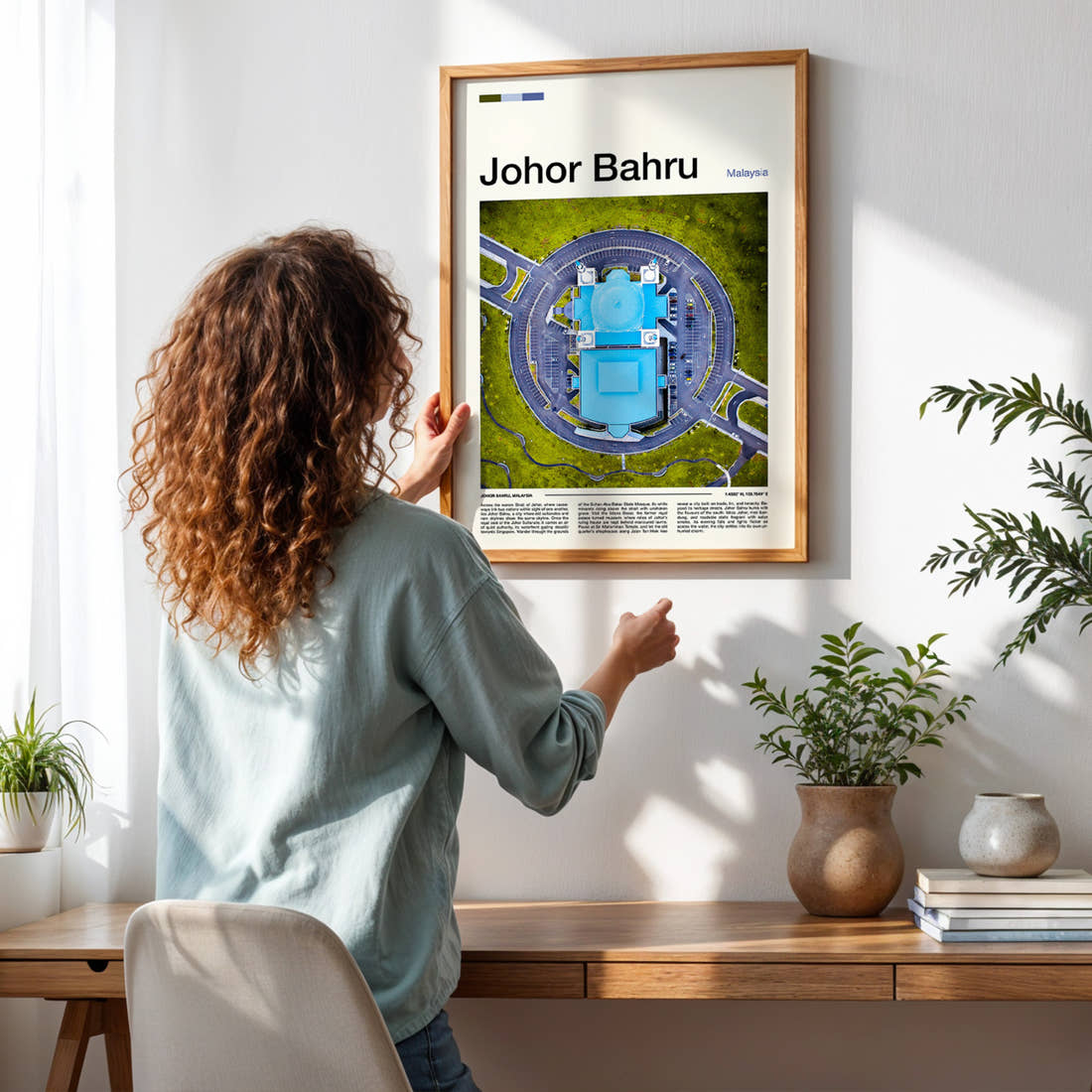 Johor Bahru Aerial Mosque View Travel Print framed on a pale wall beside houseplants
