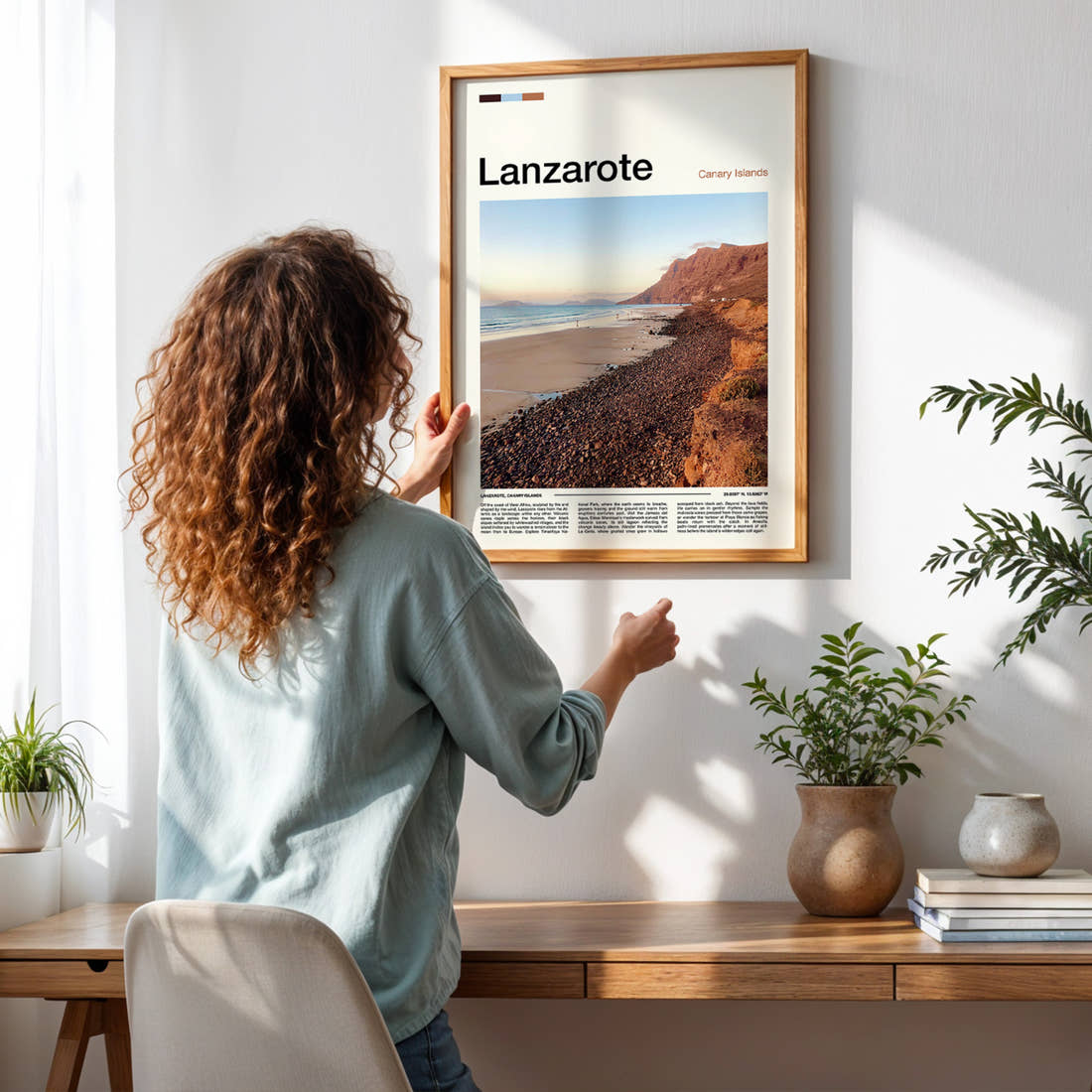 Lanzarote Volcanic Coastal Cliffs Travel Print framed on a pale wall beside houseplants