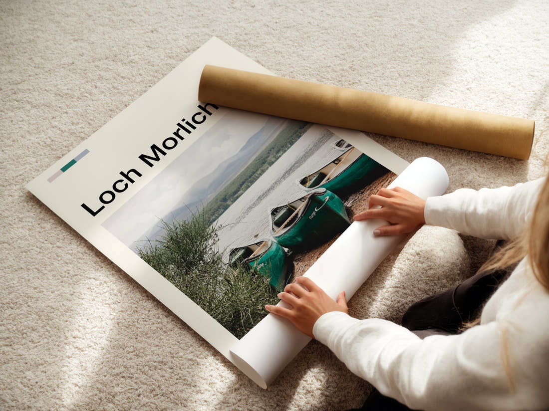 Loch Morlich Canoes On The Shore Travel Print being unrolled from its postal tube