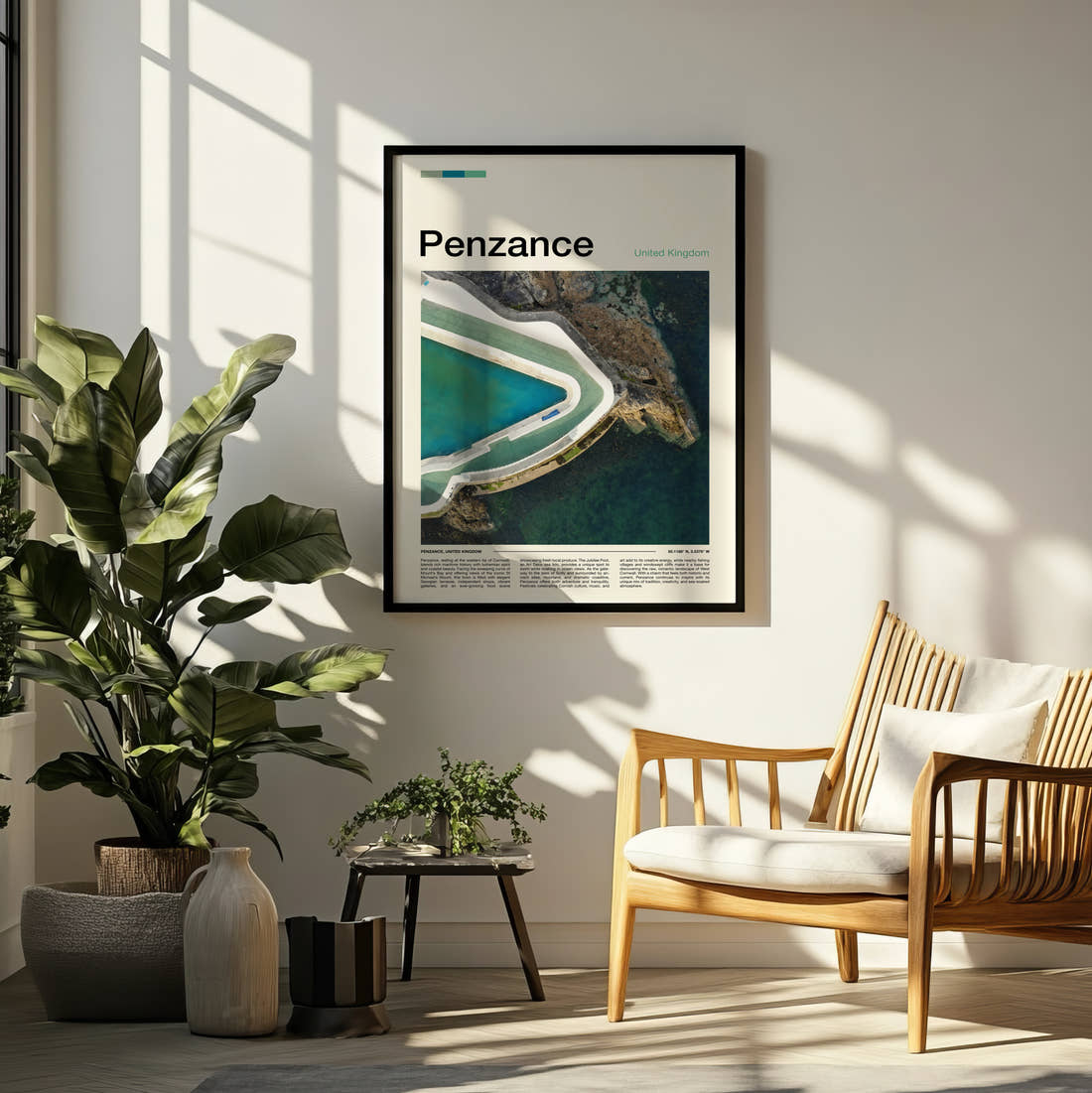 Penzance Jubilee Pool Travel Print framed on a pale wall beside houseplants