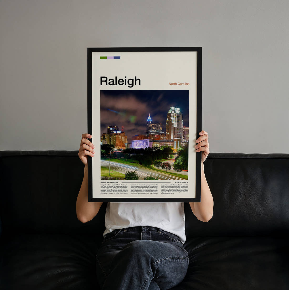 Raleigh Skyline At Night Travel Print held up by hand to show the size of the print