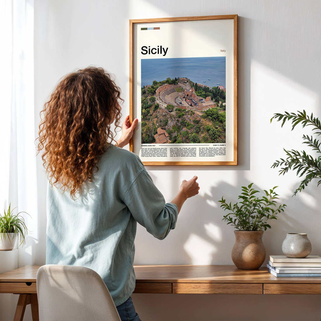 Sicily Ancient Theatre Aerial Travel Print framed on a pale wall beside houseplants