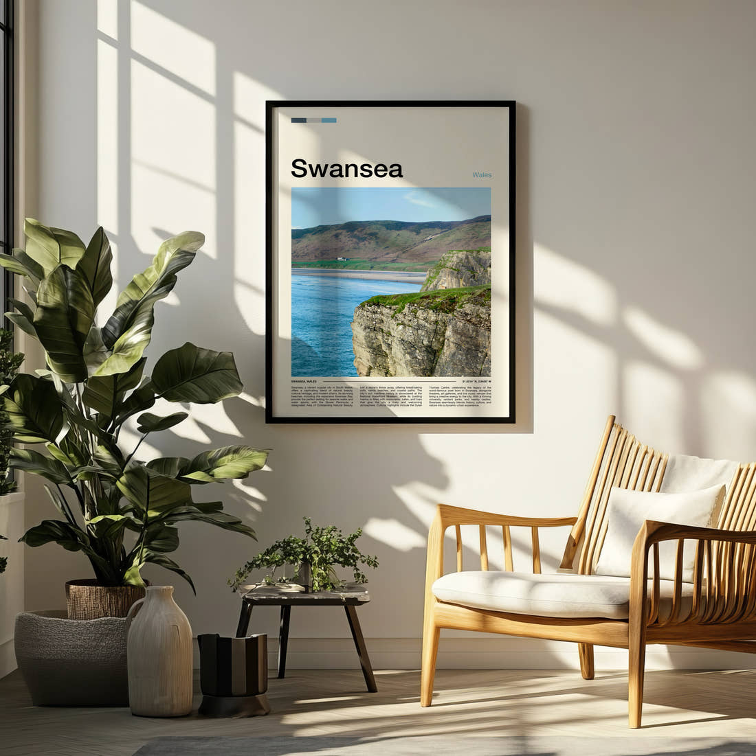 Swansea Worms Head Travel Print framed on a pale wall beside houseplants