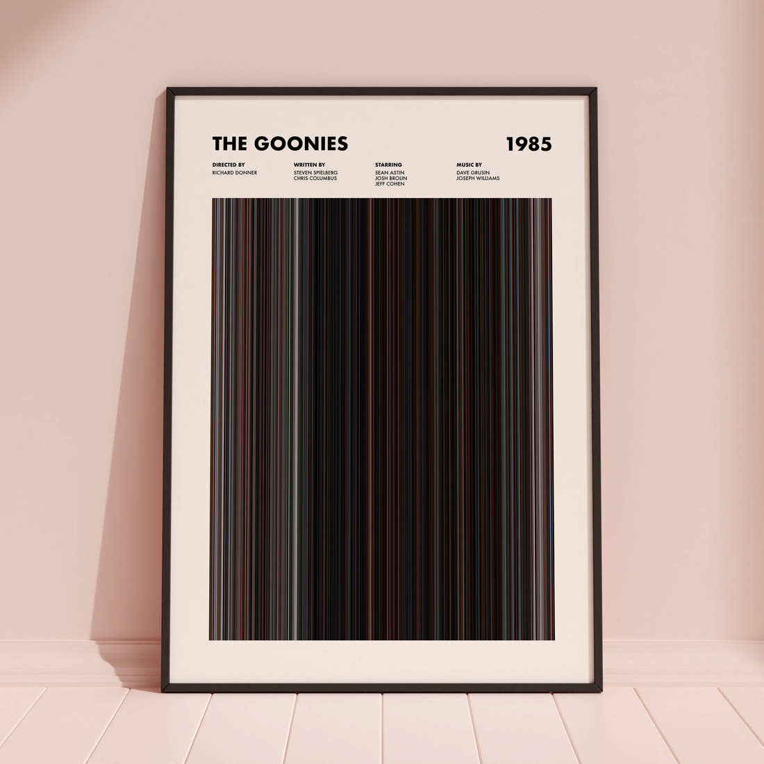 The Goonies Movie Barcode Poster framed and leaning against a coloured wall