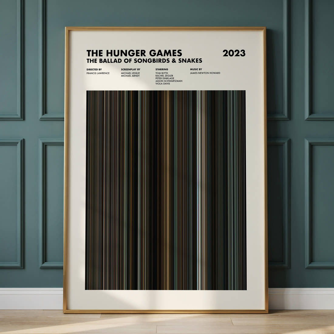 The Hunger Games: The Ballad of Songbirds & Snakes Movie Barcode Poster framed and leaning against a panelled wall