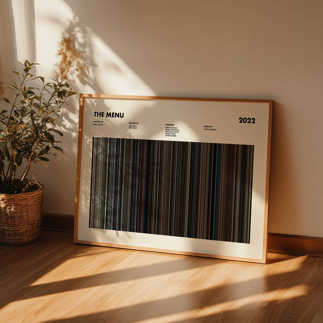 The Menu Movie Barcode Poster framed and leaning against a wall on a wooden floor