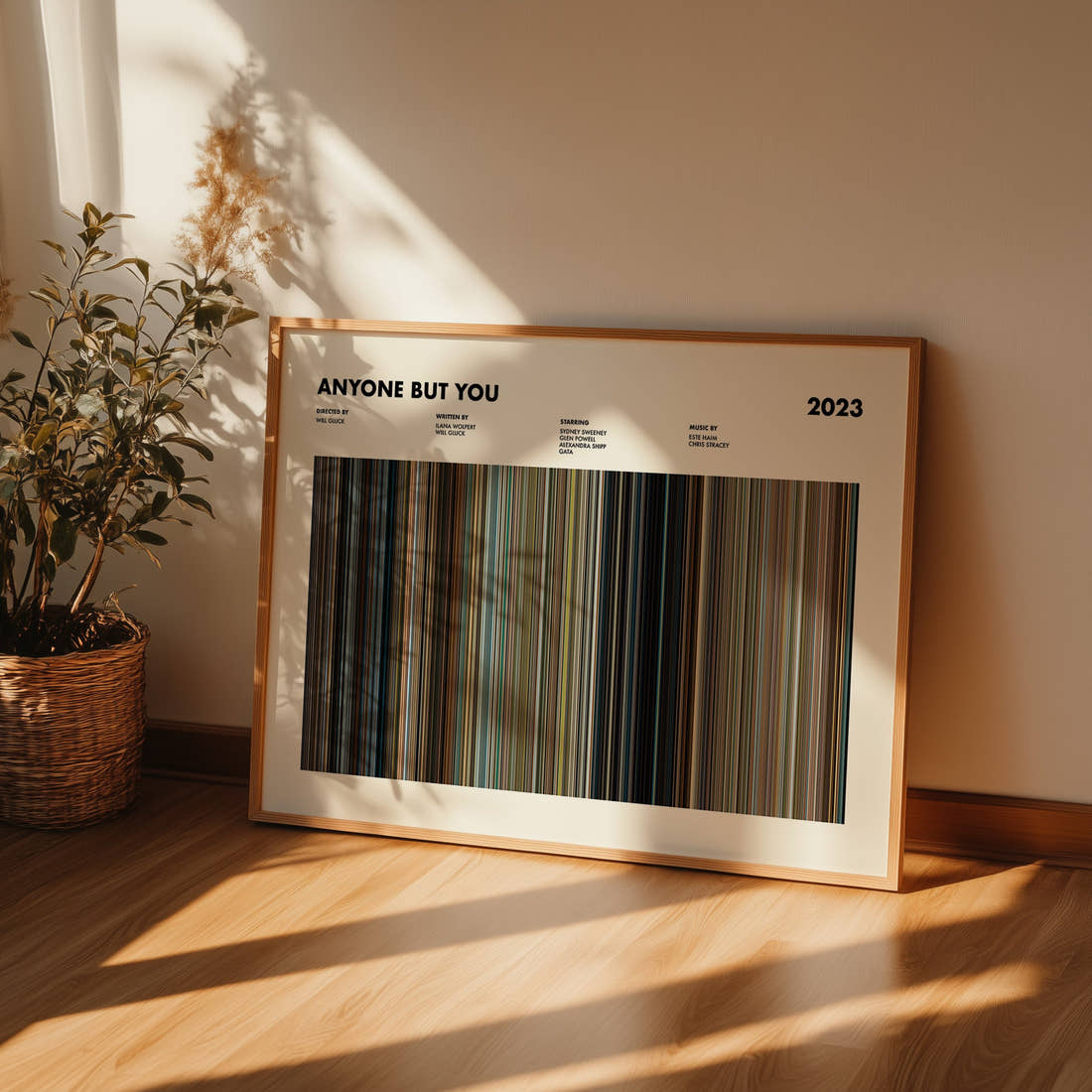 Anyone but You Movie Barcode Poster framed and leaning against a wall on a wooden floor