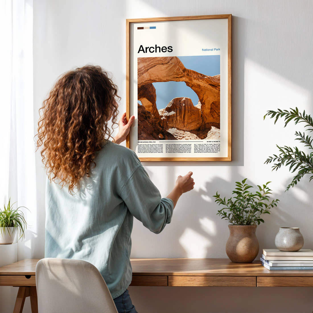 Arches Sandstone Double Arch Travel Print framed on a pale wall beside houseplants