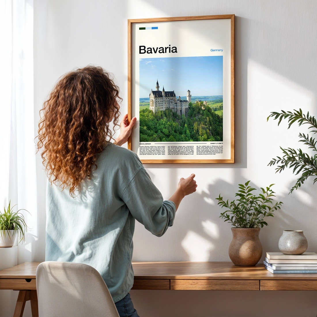 Bavaria Turreted Castle On Cliff Travel Print framed on a pale wall beside houseplants