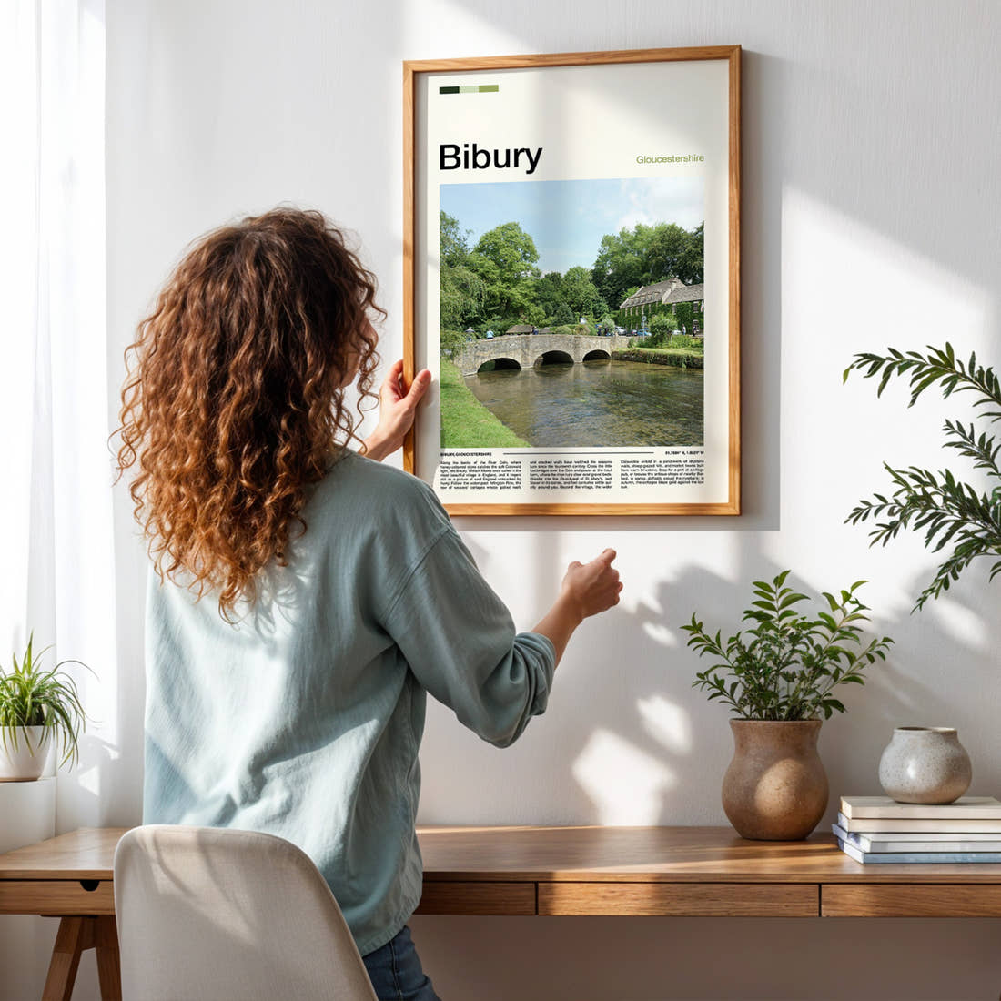 Bibury Stone Bridge Over River Travel Print framed on a pale wall beside houseplants