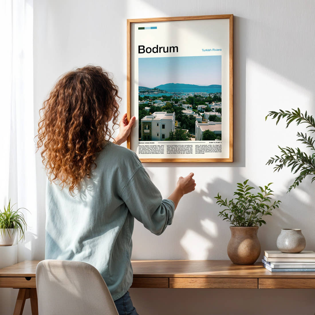 Bodrum Harbour Town View Travel Print framed on a pale wall beside houseplants