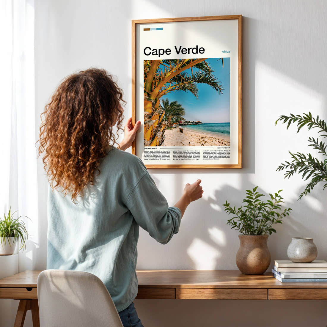 Cape Verde Palm-Fringed Beach Travel Print framed on a pale wall beside houseplants