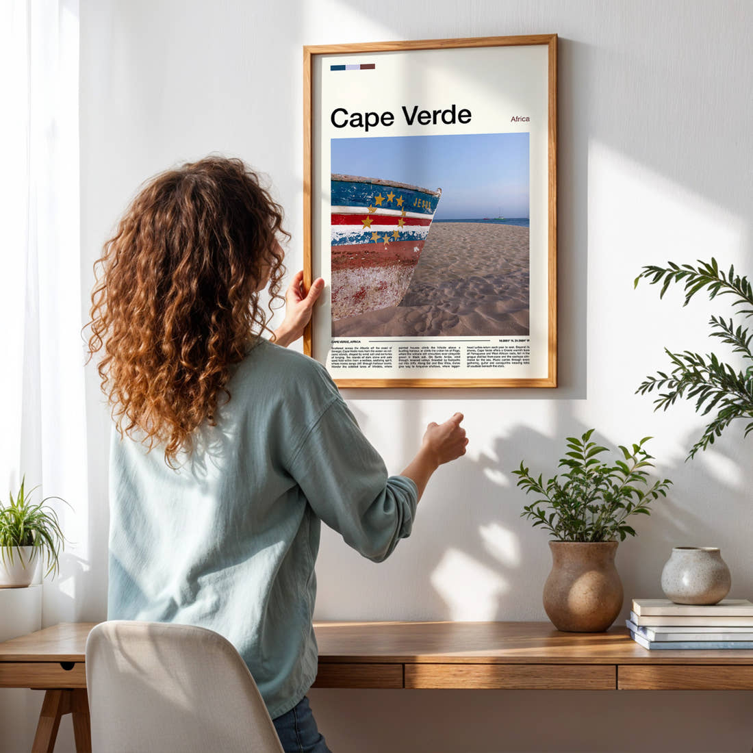 Cape Verde Weathered Fishing Boat Travel Print framed on a pale wall beside houseplants