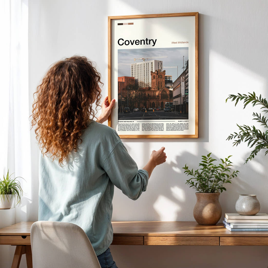 Coventry Cathedral And Skyline Travel Print framed on a pale wall beside houseplants