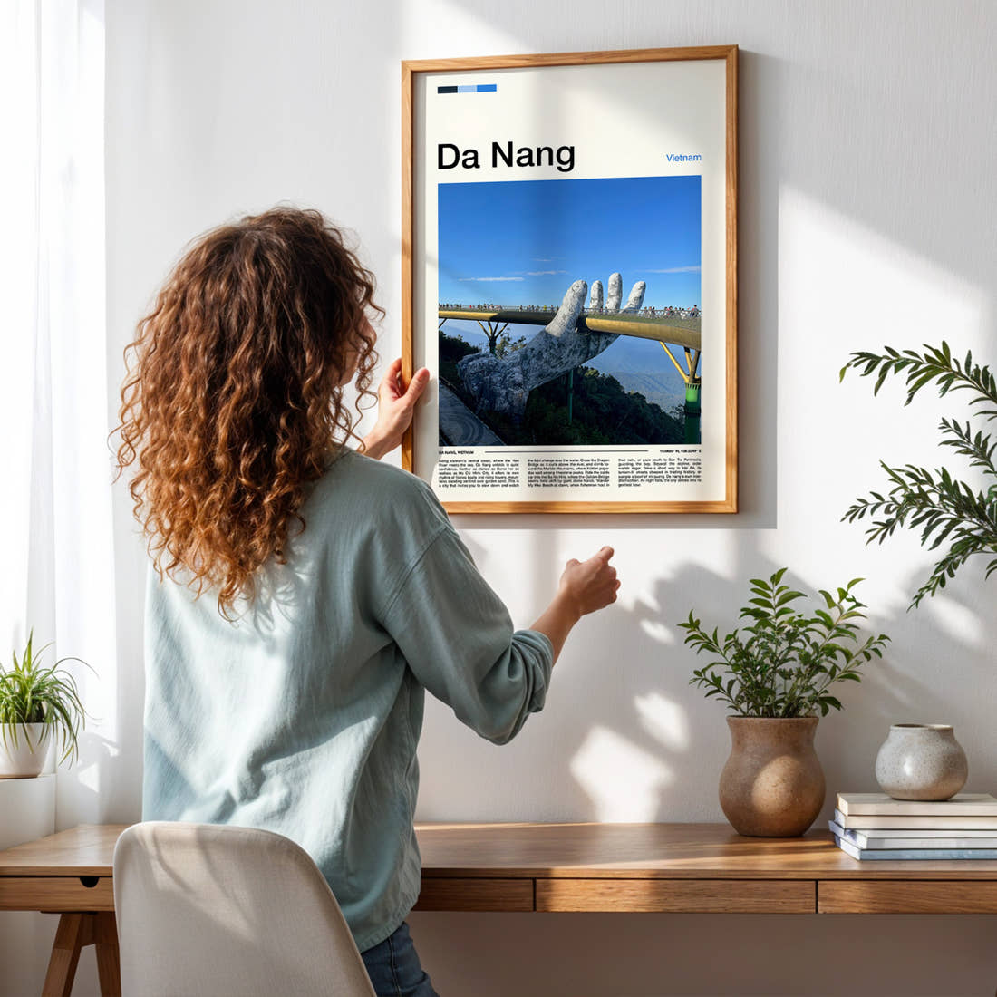 Da Nang Golden Bridge Hands Travel Print framed on a pale wall beside houseplants