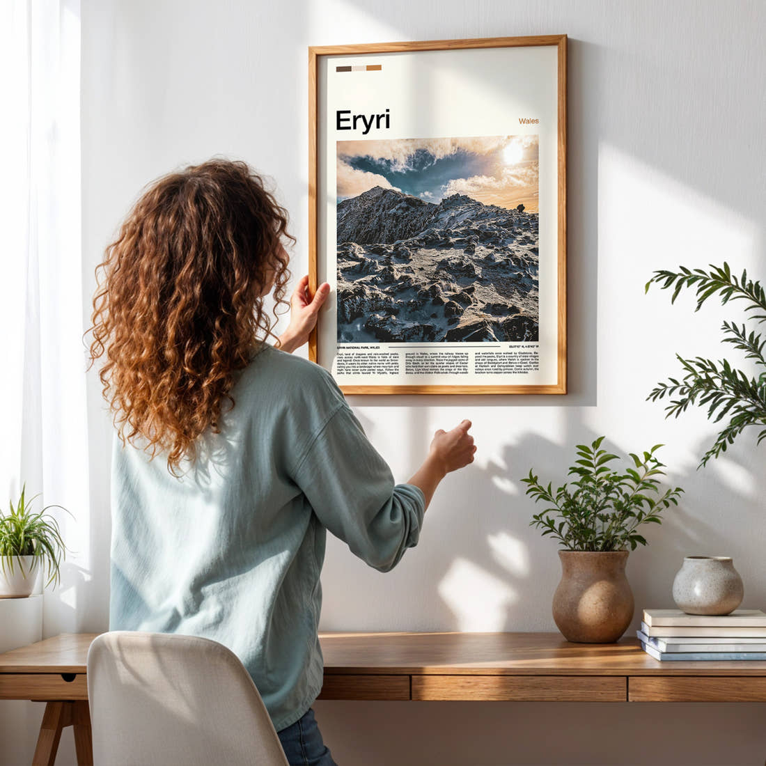 Eryri Snow-Capped Ridge Travel Print framed on a pale wall beside houseplants