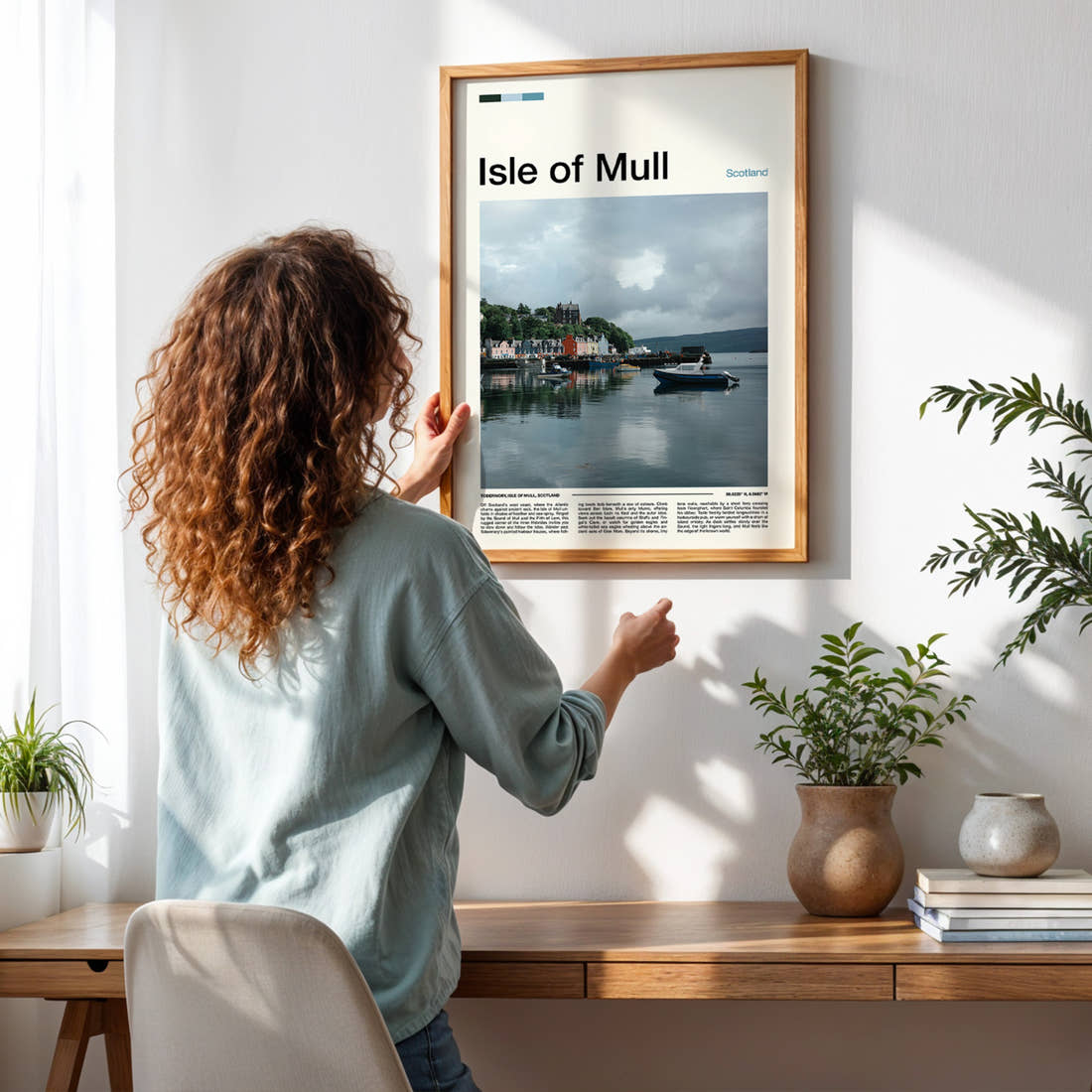 Isle of Mull Colourful Harbour Houses Travel Print framed on a pale wall beside houseplants