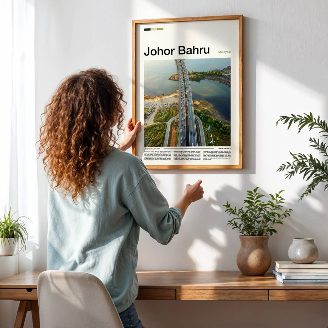 Johor Bahru Aerial Causeway View Travel Print framed on a pale wall beside houseplants