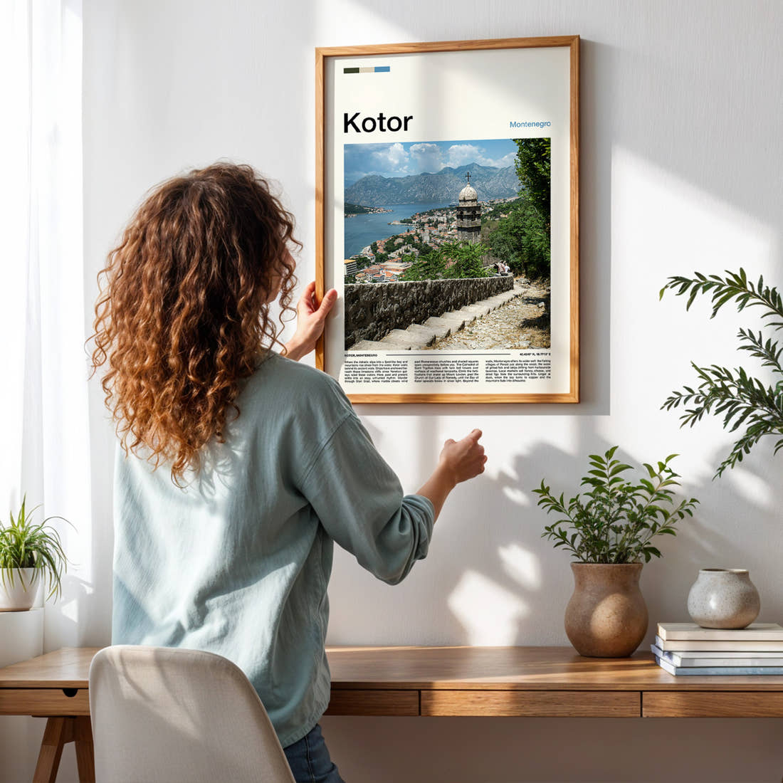 Kotor Bell Tower Overlook Travel Print framed on a pale wall beside houseplants