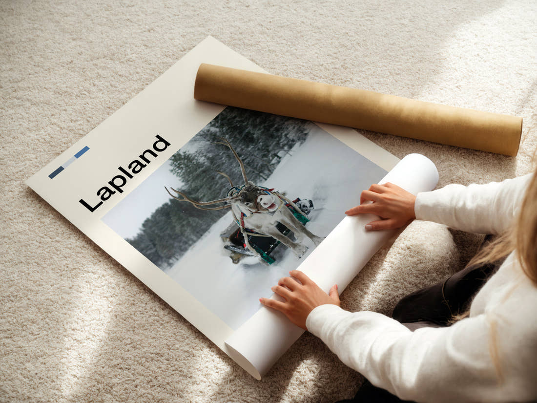 Lapland Reindeer And Sleigh Travel Print being unrolled from its postal tube