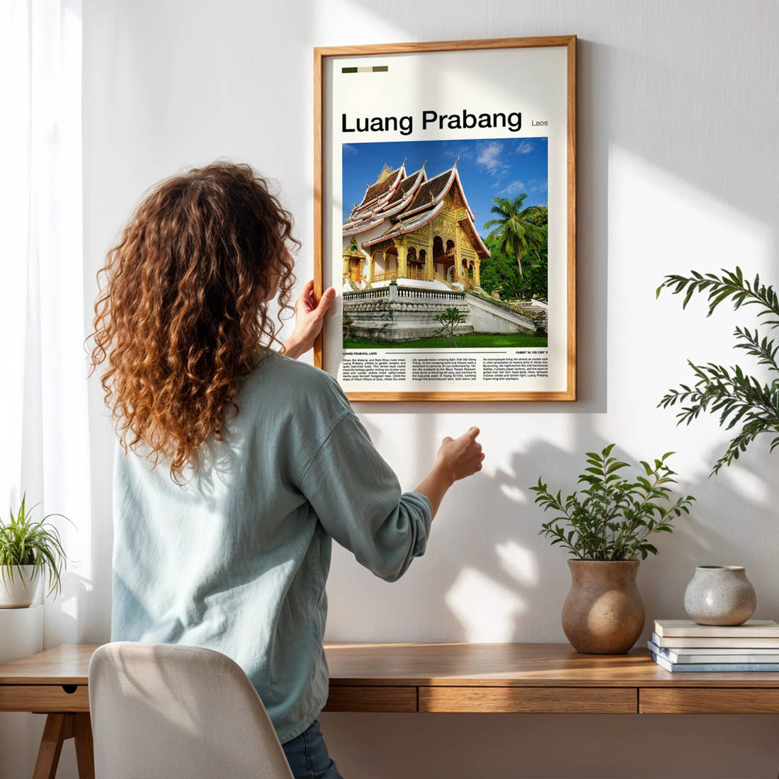 Luang Prabang Golden Temple Facade Travel Print framed on a pale wall beside houseplants
