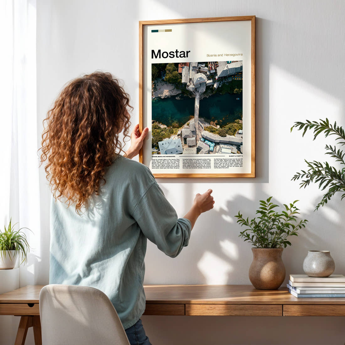 Mostar Old Bridge From Above Travel Print framed on a pale wall beside houseplants
