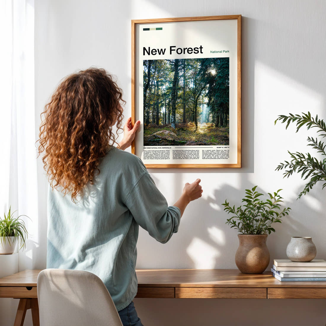 New Forest Sunlit Woodland Glade Travel Print framed on a pale wall beside houseplants
