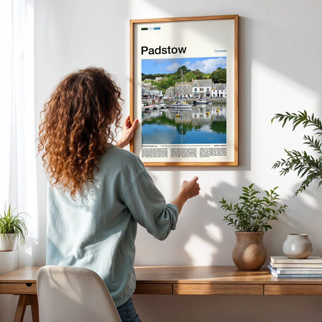 Padstow Harbour Reflections Travel Print framed on a pale wall beside houseplants