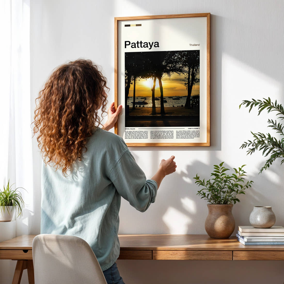 Pattaya Palm-Framed Sunset Travel Print framed on a pale wall beside houseplants