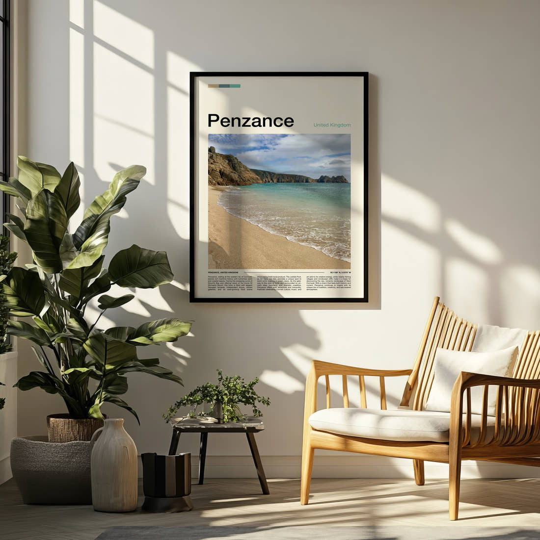 Penzance Beach And Cliffs Travel Print framed on a pale wall beside houseplants