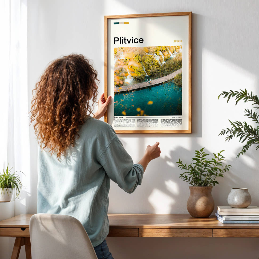 Plitvice Boardwalk From Above Travel Print framed on a pale wall beside houseplants
