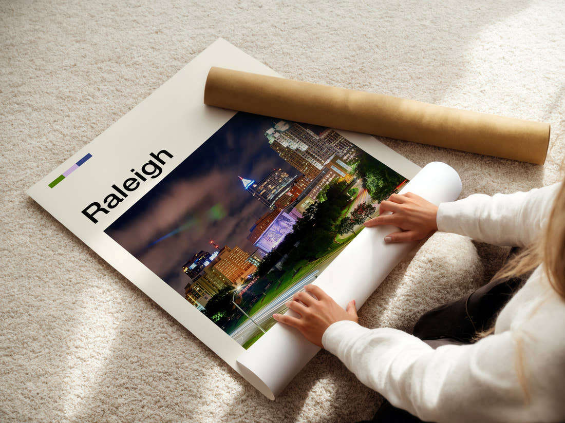 Raleigh Skyline At Night Travel Print being unrolled from its postal tube