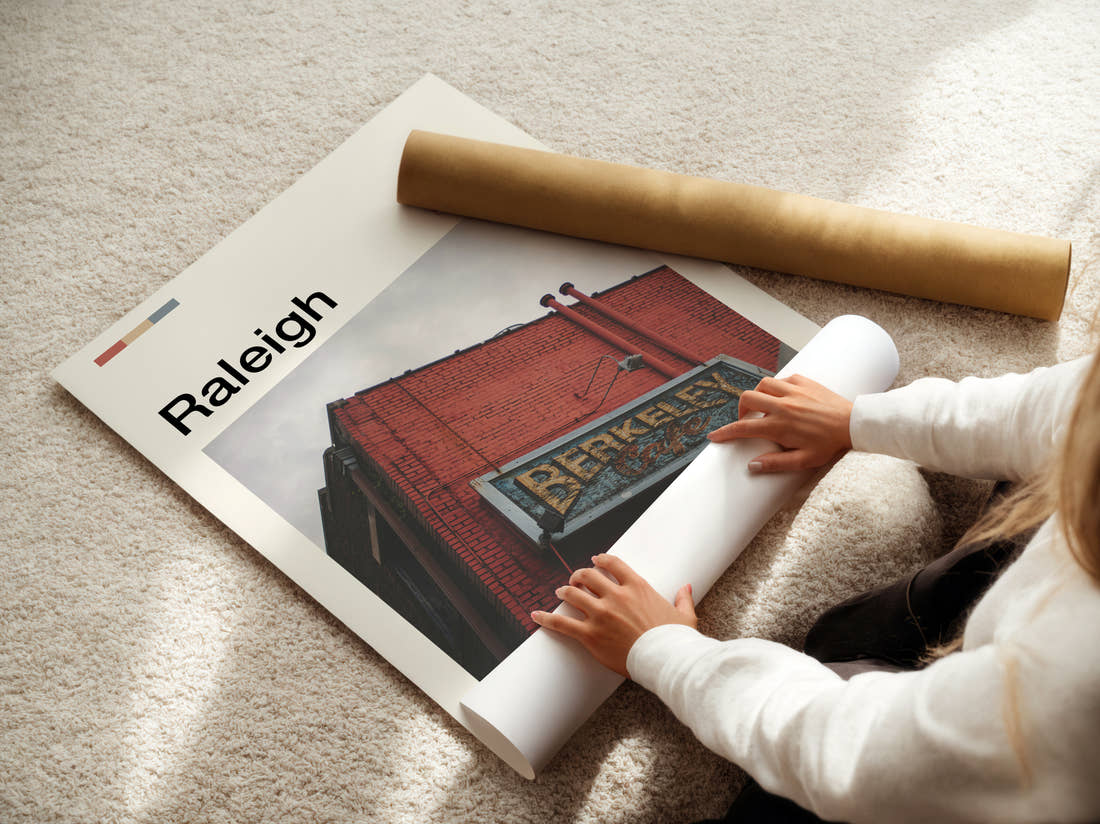 Raleigh Brick Building With Sign Travel Print being unrolled from its postal tube