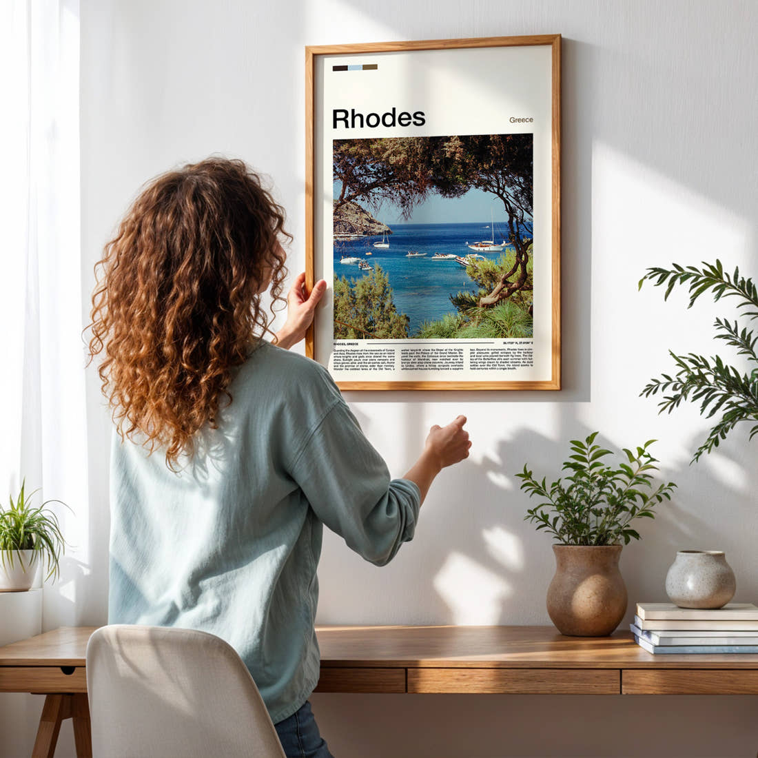 Rhodes Pine-Framed Harbour Bay Travel Print framed on a pale wall beside houseplants