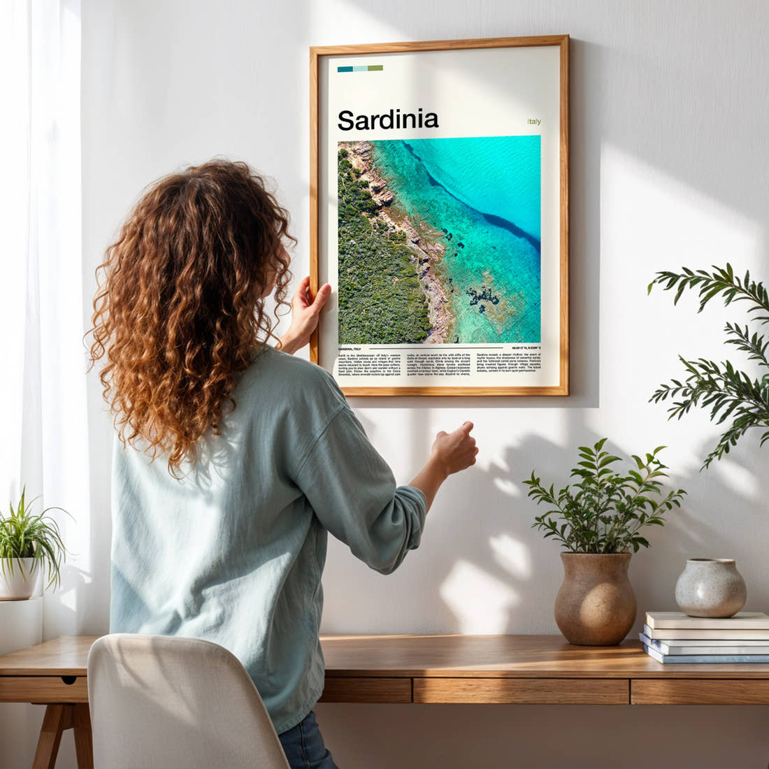Sardinia Aerial Coastline View Travel Print framed on a pale wall beside houseplants