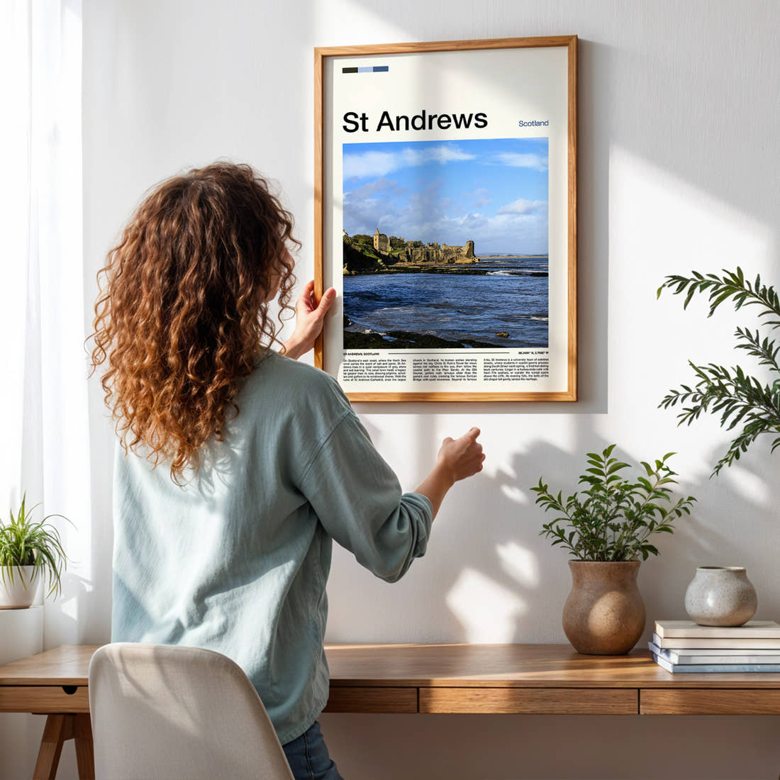 St Andrews Ruined Cathedral Coastline Travel Print framed on a pale wall beside houseplants